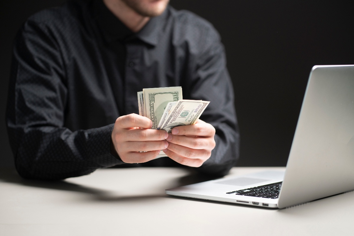 Un homme d'affaire tenant et comptant de l'argent dans son bureau