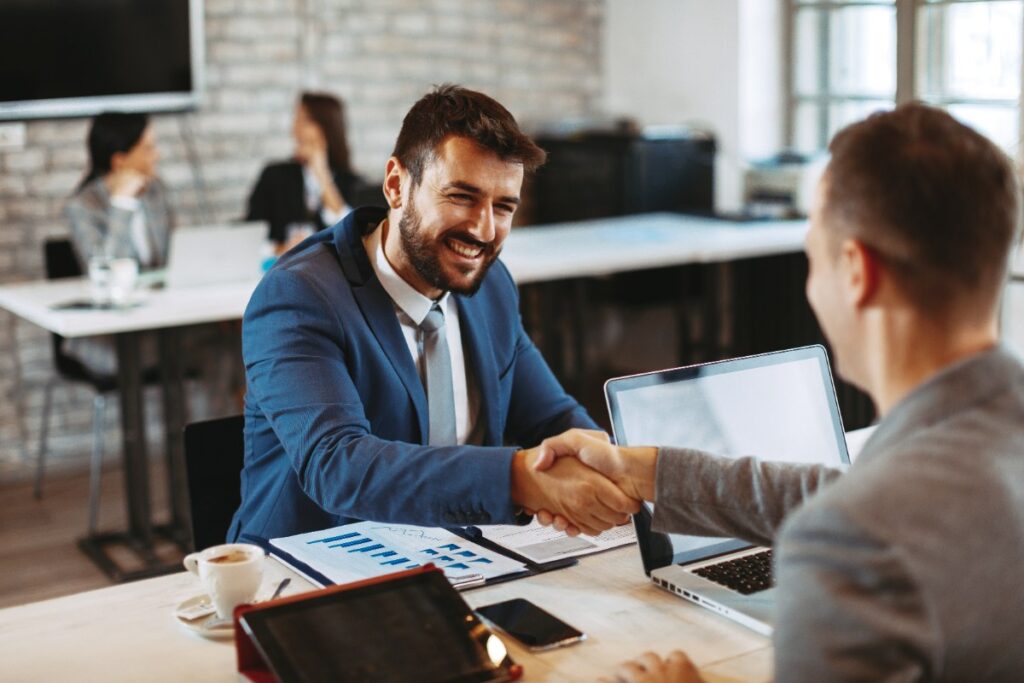 Deux hommes d'affaires concluant un marché sur une transmission pour une cession de PME