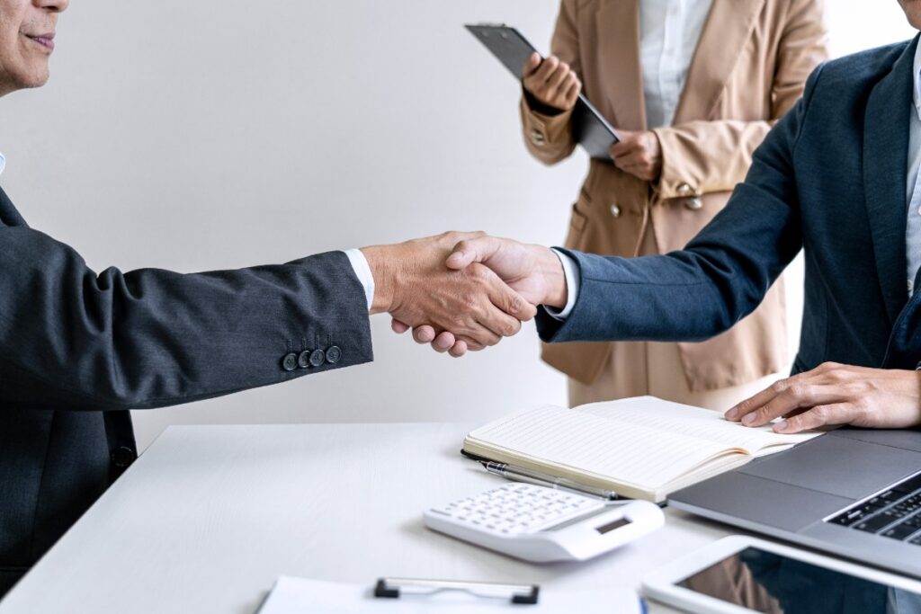 Deux personnes qui se serrent la main après une transmission d'un PME