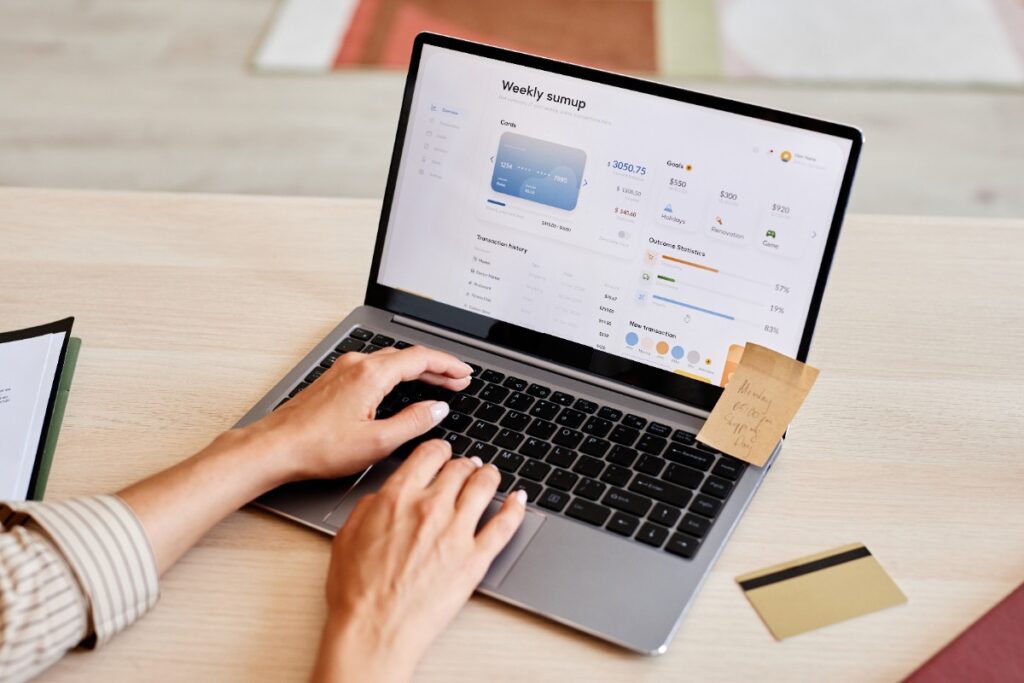 Une femme qui tape sur le clavier de l'ordinateur pour optimiser sa fiche Google My Business