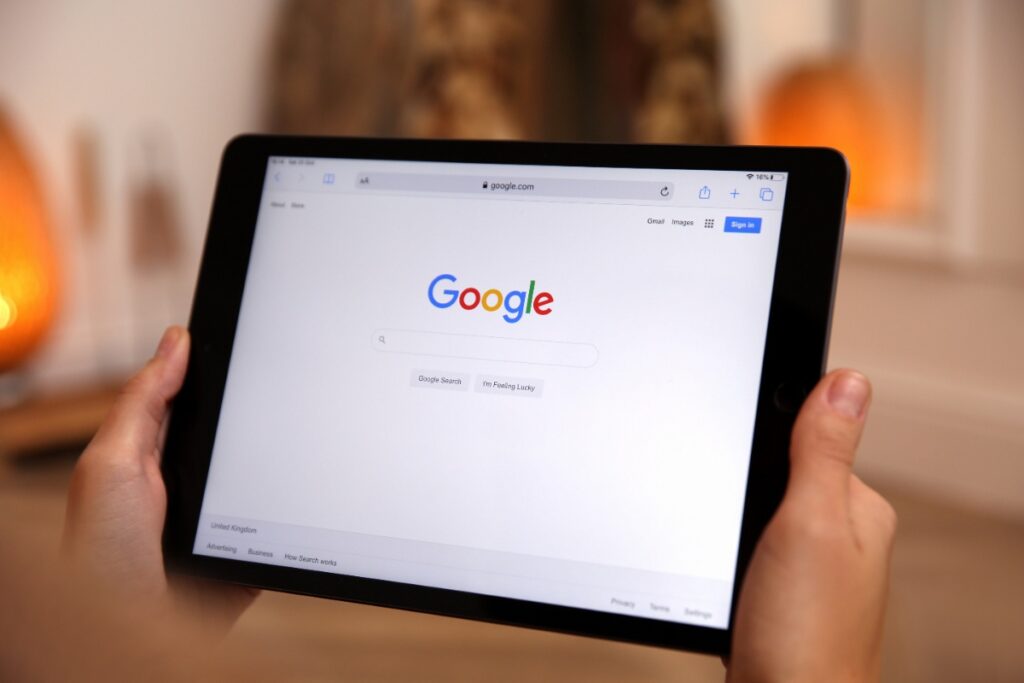 Une personne tenant une tablette et optimise sa fiche Google My Business