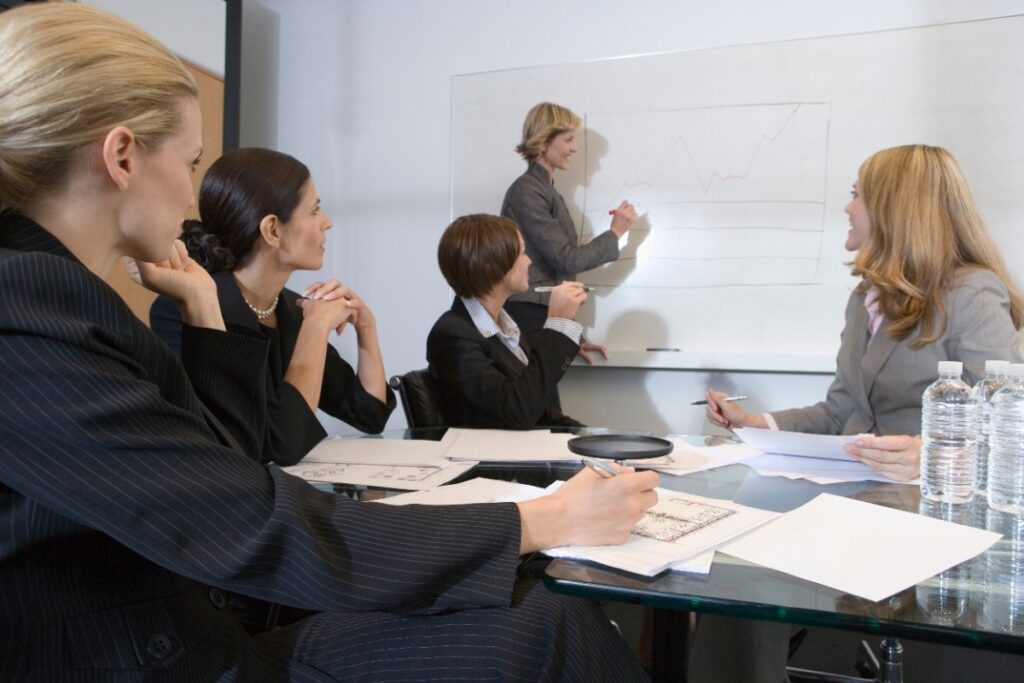 Des employés suivant un coaching collectif dirigé par un coach dans une entreprise