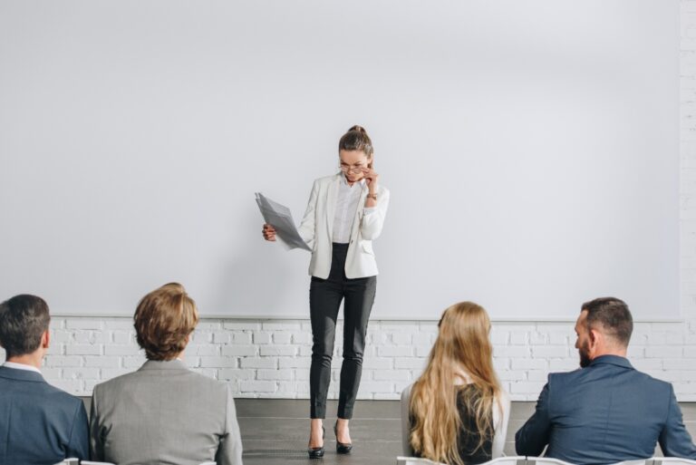 Une femme faisant un coaching collectif avec des employés