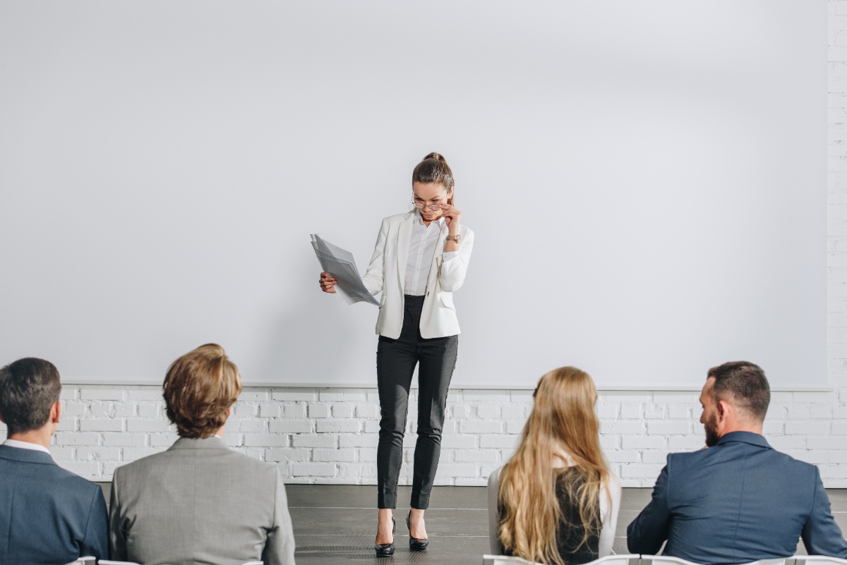 Une femme faisant un coaching collectif avec des employés