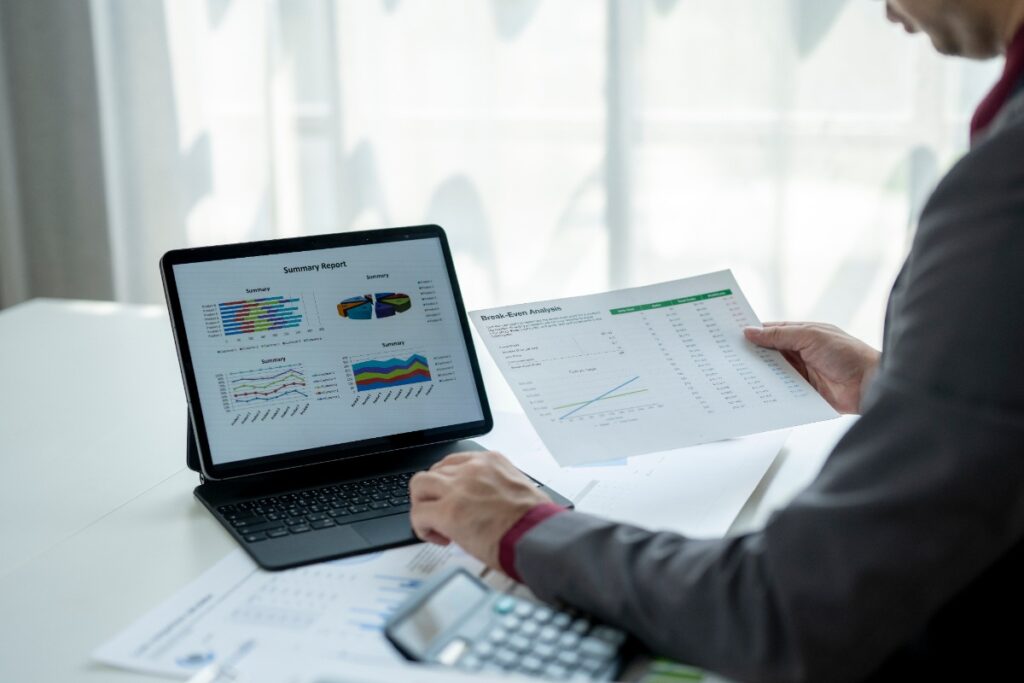 Un homme assis dans son bureau avec un ordinateur portable et des documents 