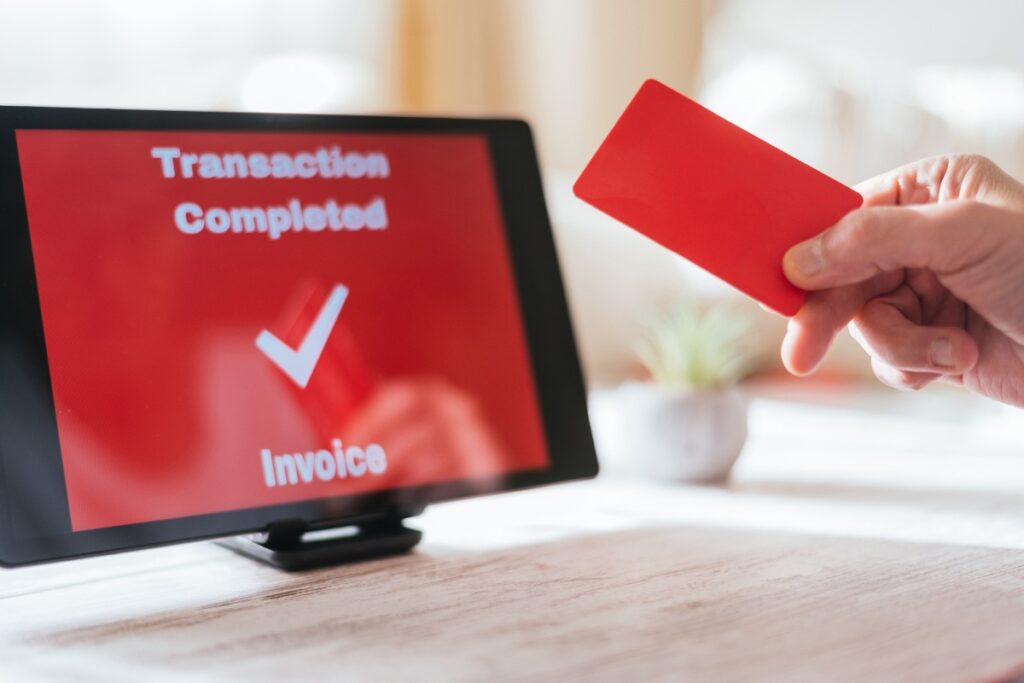 Une personne qui fait un paiement par carte bancaire via une tablette