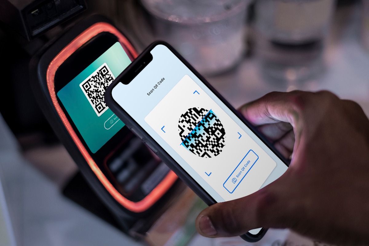 Une personne qui fait scanner un code QR avec un appareil mobile