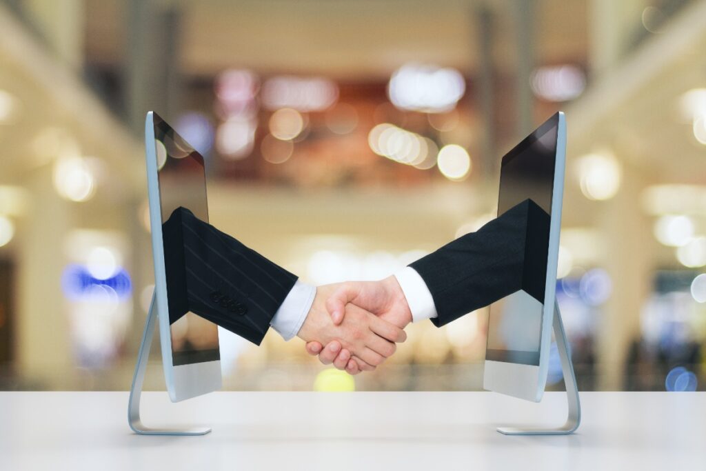 Deux mains qui se serrent pour un confirmer un accord moderne à l'aide de la technologie