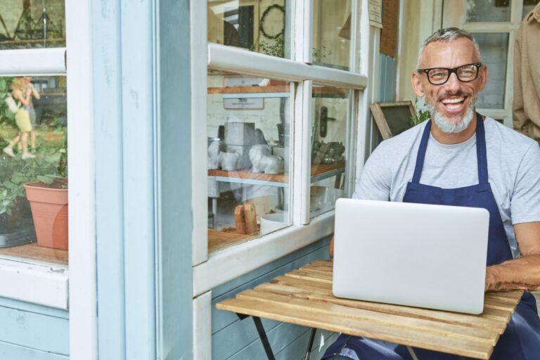 Un homme qui gère son commerce en utilisant un ordinateur portable
