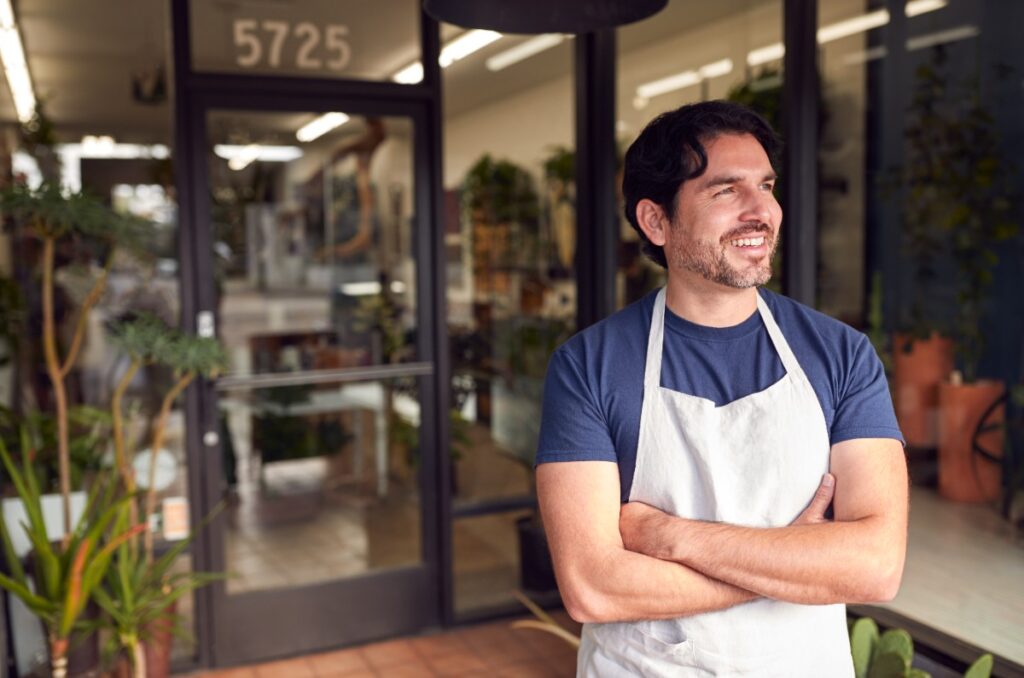 Un homme souriant devant une boutique