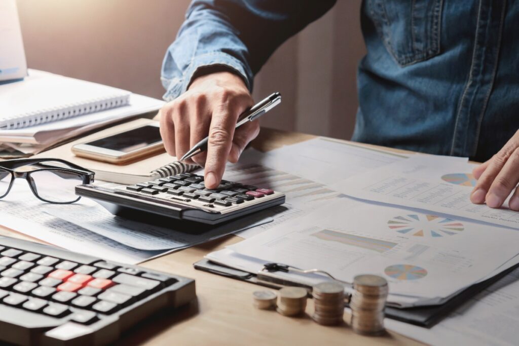 Un homme travaillant dans son bureau avec une machine à calculer