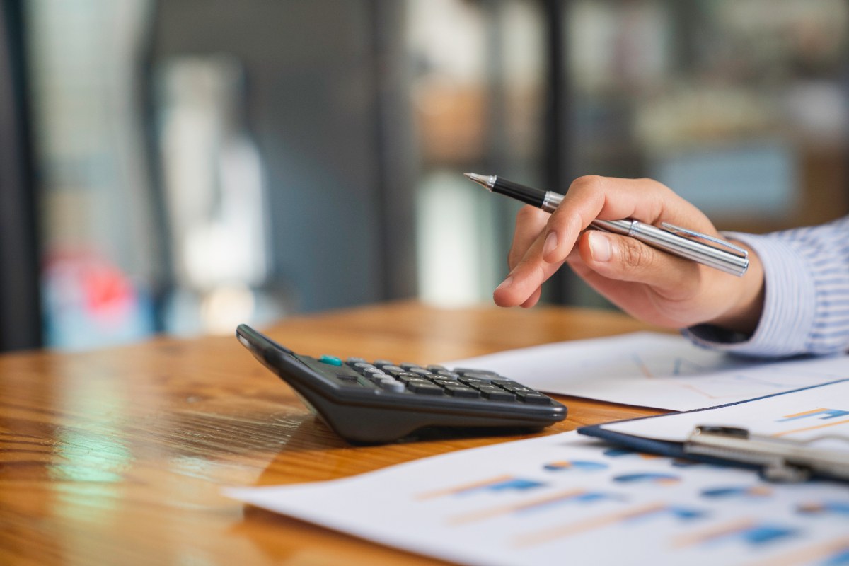 Une personne qui utilise une calculatrice sur une table de bureau