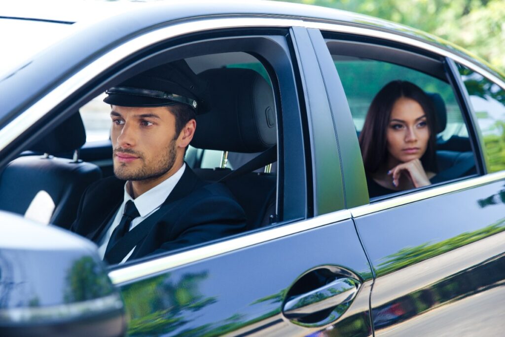 Un chauffeur qui conduit une voiture avec une femme assise à l'arrière