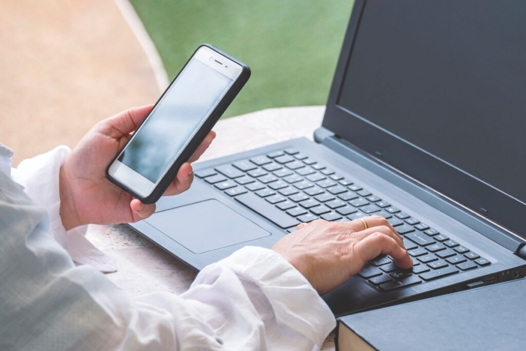 Un employé qui travaille sur son ordinateur et son téléphone