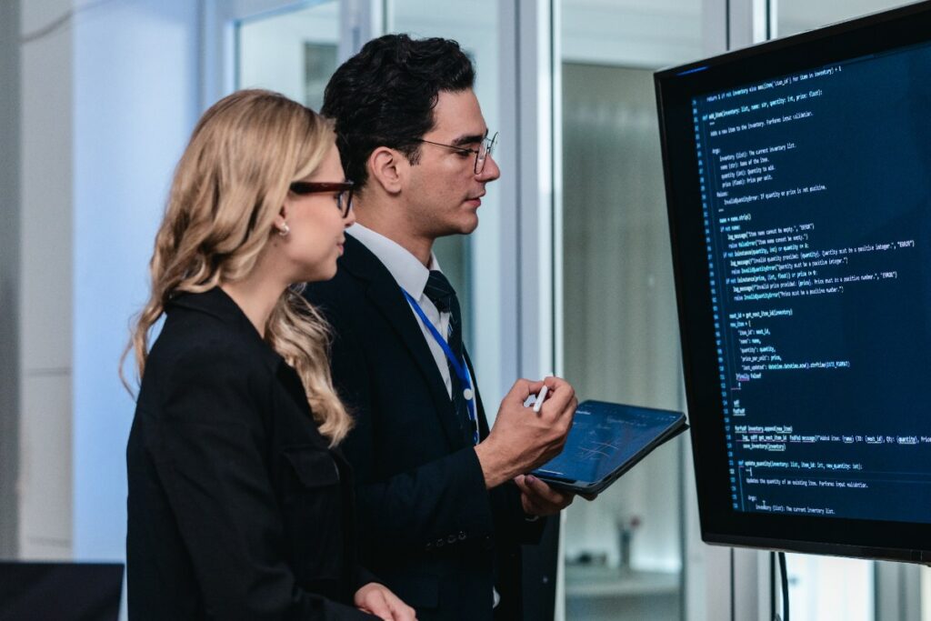 Un homme et une femme revoyant un code sur un écran