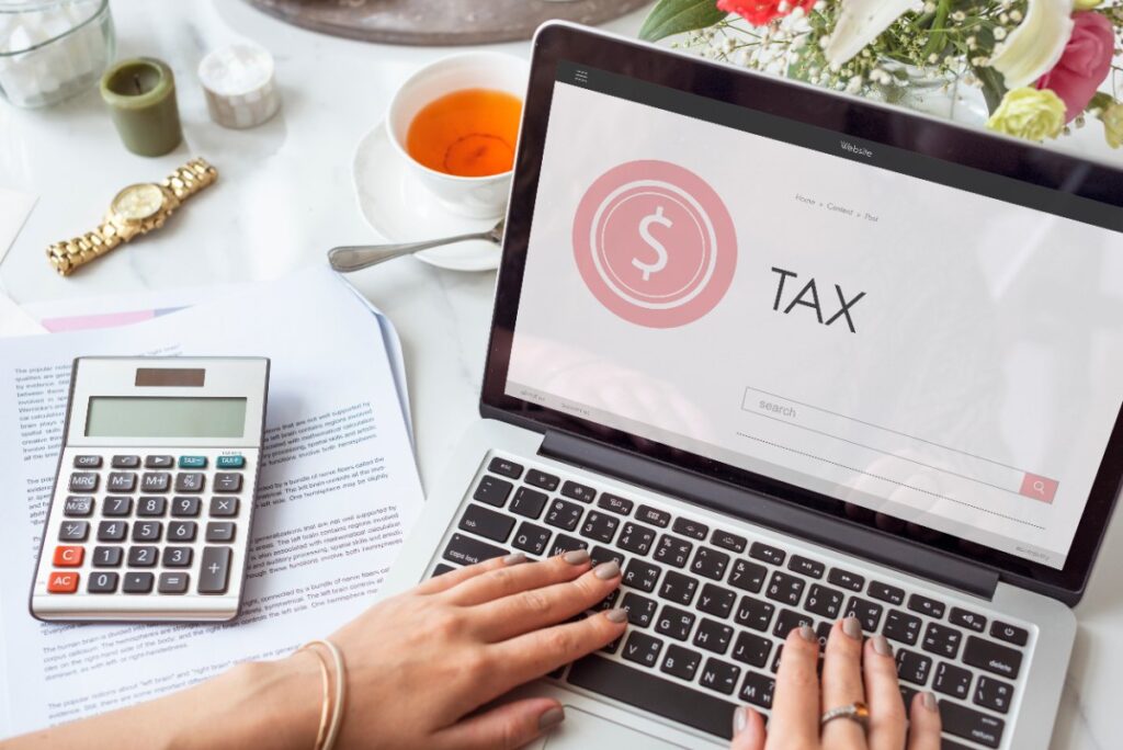 Mains tapant sur le clavier de l'ordinateur en calculant la taxe