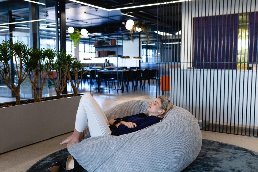 Une femme se relaxant sur un pouf dans un bureau moderne