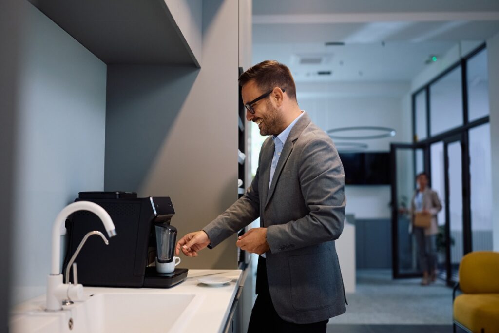 Un homme d'affaires heureux utilisant la machine à café