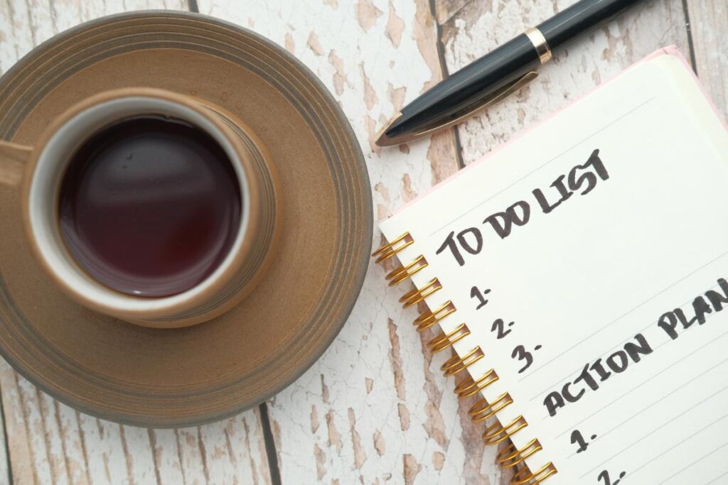 Liste des choses sur un carnet avec une tasse de café et un stylo sur la table