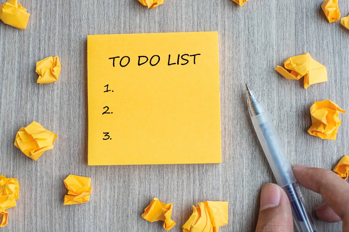 Une personne tenant un stylo et faisant une liste des choses